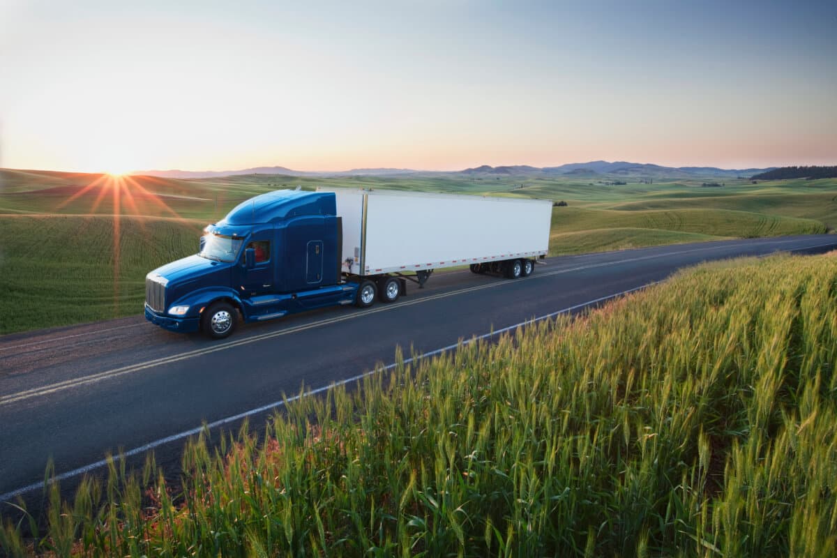 big-blue-truck-driving-on-a-remote-highway-insurance.jpg